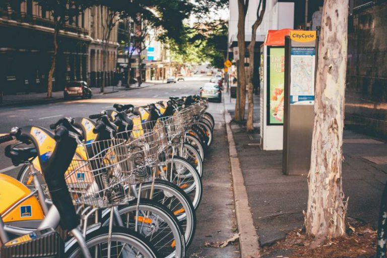 Cycling Road Australia - assorted commuter bicycle park ahead near yellow car at daytime