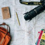 Eco Travel Australia - flat lay photography of camera, book, and bag