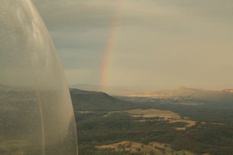 Glamping Tent Australia - a view of a rainbow from a plane window