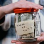 A Person Holding a Container Full of Money